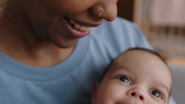 Primer plano de la joven y feliz mujer afroamericana besando a su pequeño hijo en la mejilla mientras pasaban el día juntos en casa - Imágenes, Vídeo