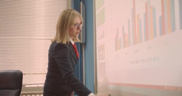 Profesor escribiendo notas en el tablero inteligente mientras da conferencias a los estudiantes en la clase universitaria - Metraje, vídeo