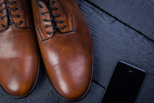 Brown leather shoes on black floor - Zdjęcie, obraz