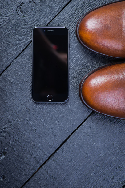 Brown leather shoes on black floor - Фото, зображення