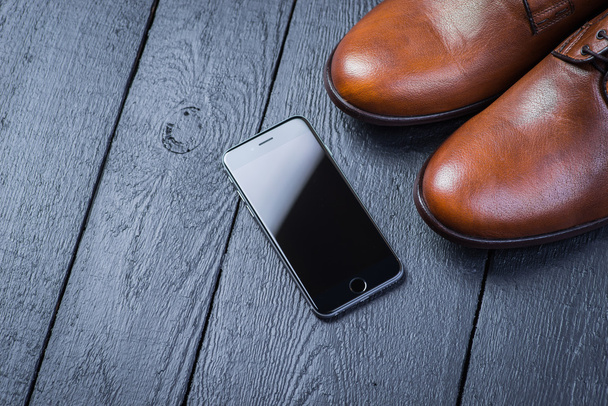Brown leather shoes on black floor - Фото, зображення
