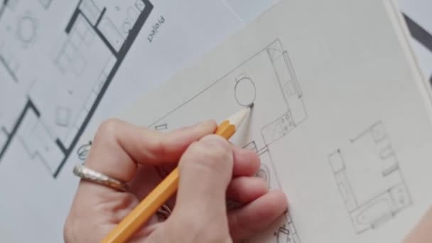 Vertical de irreconocible mujer interiorista dibujo planta apartamento con lápiz en cuaderno de bocetos - Metraje, vídeo