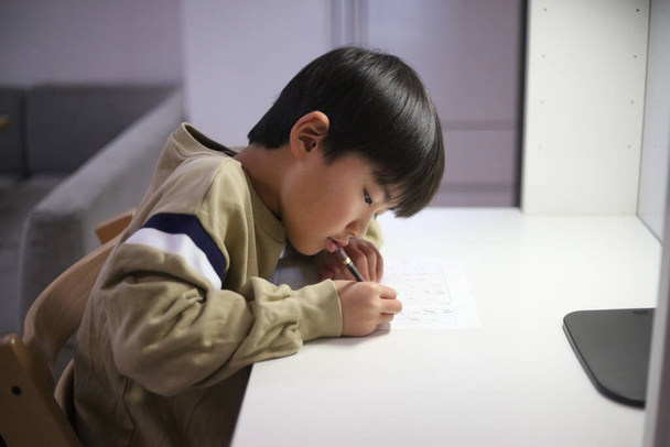 Egy fiú, aki kalligráfiát gyakorol - Fotó, kép