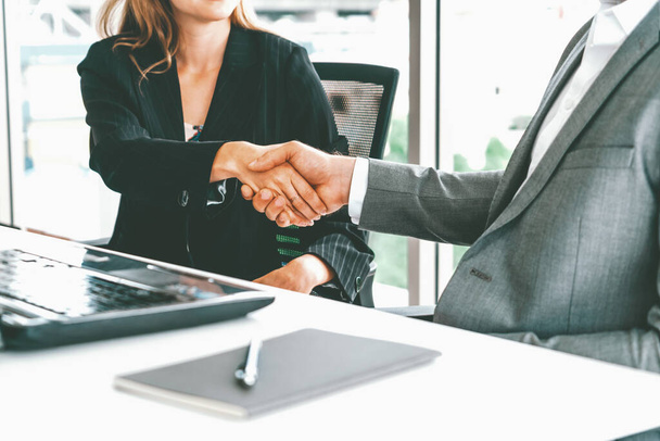 Handschlag zwischen Geschäftsmann und Geschäftsfrau in einem modernen Büro am Arbeitsplatz. Menschen Corporate Business Deals Konzept. uds - Foto, Bild