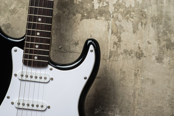 Elektromos gitár, a szürke beton fal közelében - Fotó, kép