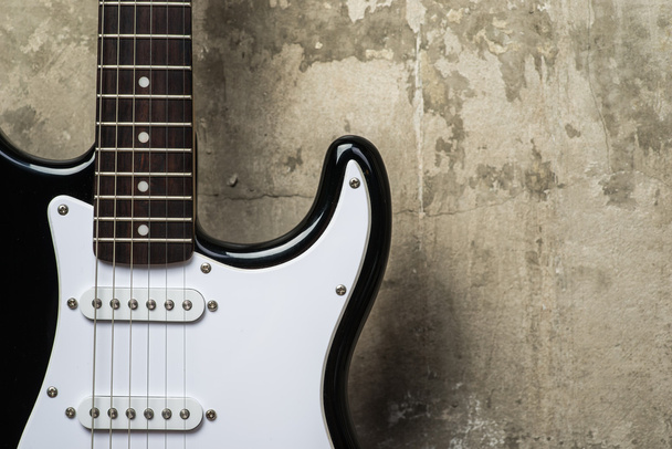 Elektromos gitár, a szürke beton fal közelében - Fotó, kép