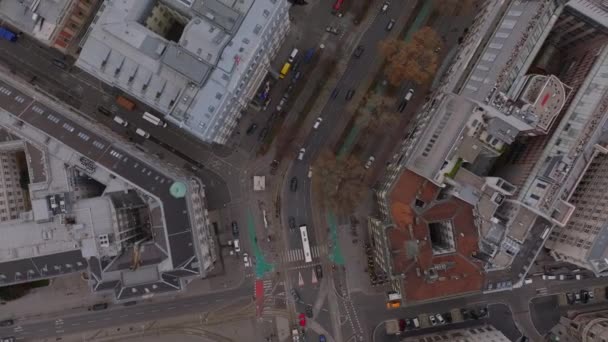 Duży kąt widzenia pojazdów jadących przez zimowe miasteczko. Ulice i duże budynki w dzielnicy miejskiej. Wiedeń, Austria. - Materiał filmowy, wideo