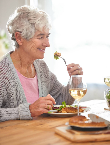 Вино, посмішка і старша жінка за столом зі здоров'ям, святкування і відпочинок в будинку престарілих. Їжа, напої та старенька їдять у їдальні з щасливим бранчем, харчуванням та вихідними - Фото, зображення