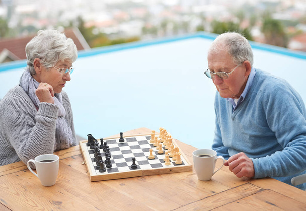Шахматы, игры и старшая пара на открытом воздухе вместе в отставке, чтобы расслабиться с конкуренцией стратегии. Мышление, вызов и пожилые мужчина и женщина с активностью на борту во время отпуска или отпуска. - Фото, изображение