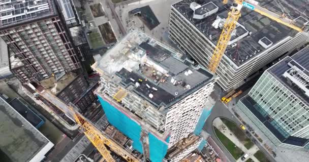 Утрехт, Нідерланди, 7 лютого 2024 року: будівельний майданчик на висотній будівлі та панорама центру Утрехта на задньому плані. Крани і будівельники в експлуатації. Повітряні - Кадри, відео