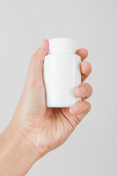 Tenant une bouteille blanche de pilules
 - Photo, image