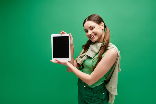 Eine junge Frau in ihren Zwanzigern, die ein Tablet in der Hand hält, beschäftigt sich mit der digitalen Welt. - Foto, Bild