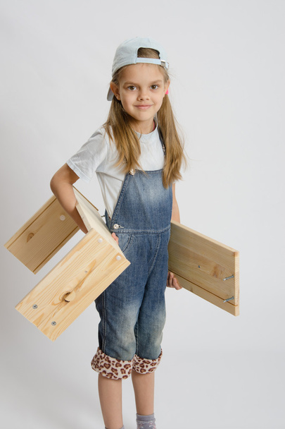 Portret van een zes-jarige meisje met planken in handen - Foto, afbeelding