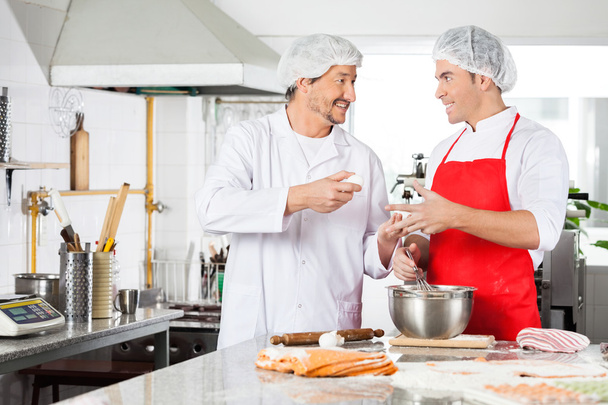 Happy Chefs Discussing While Preparing Ravioli Pasta At Counter - Fotó, kép
