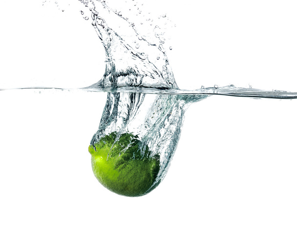 Fresh lime falling into water - Фото, изображение