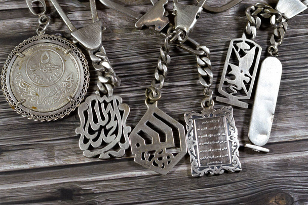 Cairo, Egypt, February 19 2024: Silver medals with various shapes and commemorations, 5 Egyptian silver coin of Arab League golden Jubilee, Islamic medals with Quran, Allah and Pharaonic symbol medals - Photo, Image