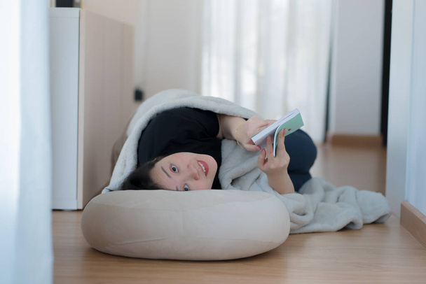 Концепція здоров'я та благополуччя з азіатською жінкою лягає і читає книгу у вітальні - Фото, зображення