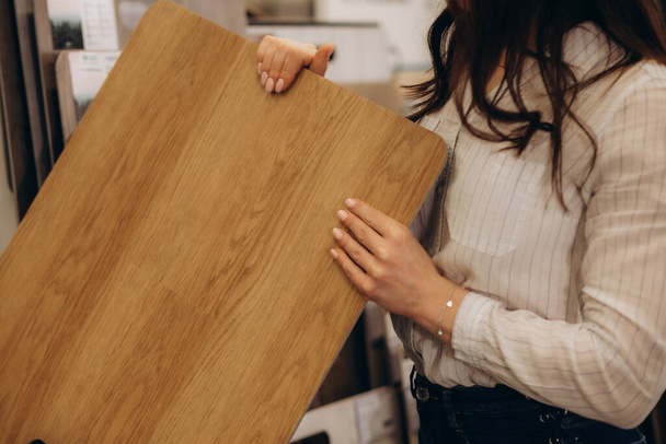 femme choisissant plancher stratifié en bois dans la boutique. réparation de la maison. Photo de haute qualité - Photo, image