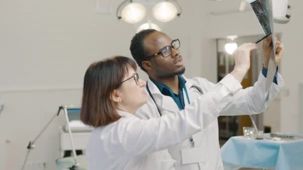 Uomo e donna di colore in camici bianchi in ambulatorio medico - Filmati, video