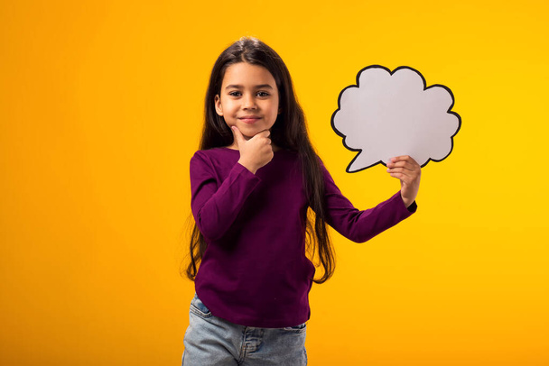 Porträt eines nachdenklichen Mädchens mit einer Wolkenblase auf gelbem Hintergrund. Traum-Konzept - Foto, Bild