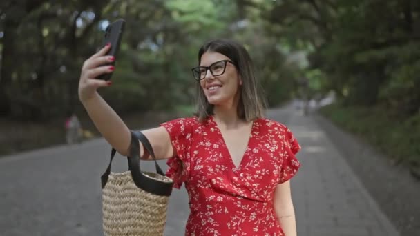 Gyönyörű spanyol nő szemüvegben, amelynek vidám szórakoztató szelfi kép okostelefonnal a híres Meiji templom, tokyo - Felvétel, videó