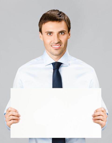 Business man showing blank signboard, over gray - Fotó, kép