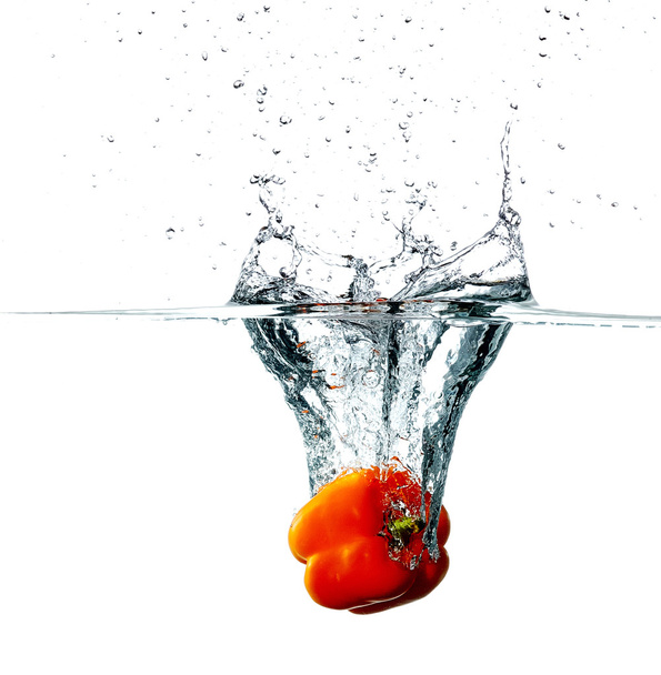 Pepper drops into a water - Foto, afbeelding