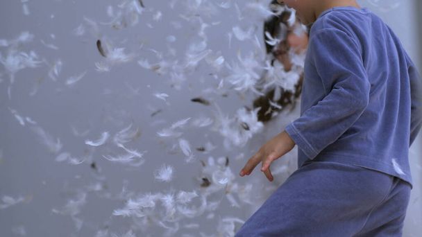 Подушка Пандемонія - Радісні діти та повітряні пір'я, простирадла, прикрашені оперенням у ліжку - Фото, зображення