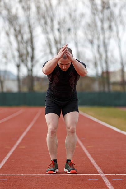 Gesunder Mann läuft auf Leichtathletik-Rennbahn und repräsentiert c - Foto, Bild