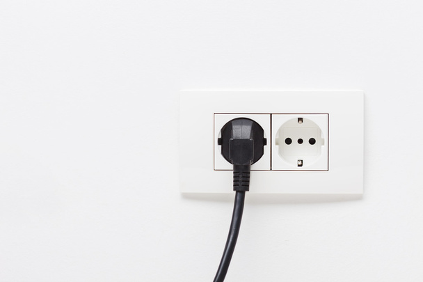 Electric cord plugged into socket - Valokuva, kuva