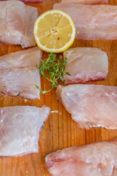 fresh raw fish slices with lemon on wooden cutting board - Foto, Imagen