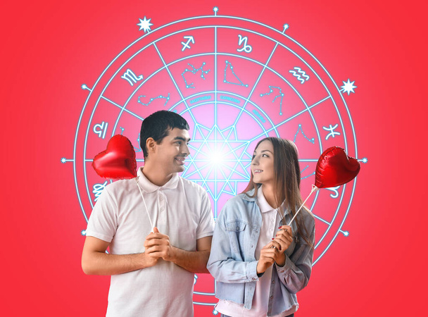 Portrét mladého páru s balónky ve tvaru srdce a kreslenými zvěrokruhovými znaky na červeném pozadí. Miluju horoskop kompatibility. Partner odpovídající datu narození - Fotografie, Obrázek