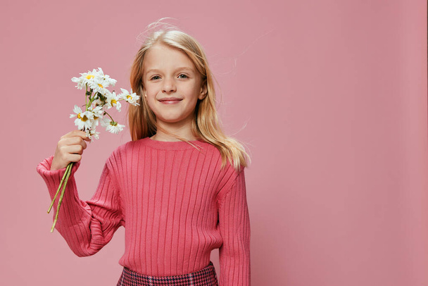 Joyful Mothers Day Celebration with a Cute Blonde Schoolgirl holding a Pink Flower Lovely Emotions and Magic filled the air as the Little Girl presented a Adorable Present Surrounded by Pretty - Photo, Image