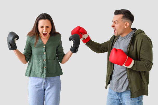 ボクシングの若いカップル 光の背景で喧嘩の手袋 - 写真・画像