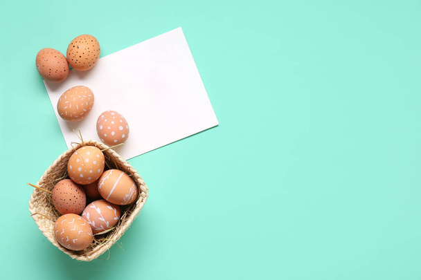 Πασχαλινά αυγά και κενή ευχετήρια κάρτα σε τυρκουάζ φόντο. Άνω όψη - Φωτογραφία, εικόνα