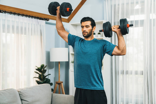 Atletik vücut ve aktif sporcu, sağlıklı vücut egzersizi yaşam tarzı konsepti olarak Gaiety Home 'da kas kazancını etkin bir şekilde hedeflemek için halter ağırlığını kaldırıyor.. - Fotoğraf, Görsel
