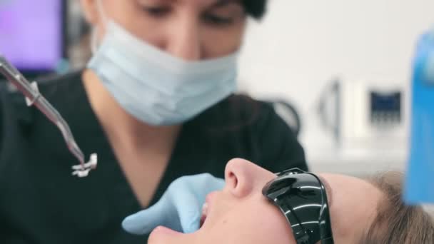 Hammastarkastus käynnissä, lähikuva hammaslääkärin ja potilaan kanssa nykyaikaisessa klinikassa - Materiaali, video