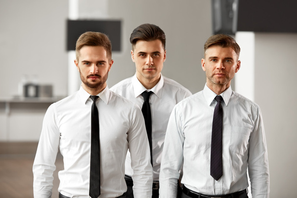 Trzech biznesmenów stoi w biurze - Zdjęcie, obraz