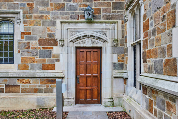 Michigan Üniversitesi Hukuk Fakültesi 'nde yontulmuş taş kemerli zarif ahşap kapı. - Fotoğraf, Görsel
