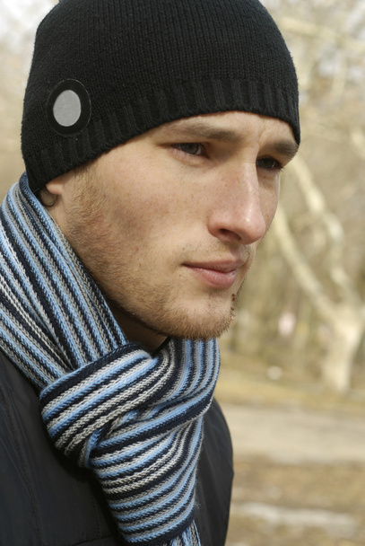 Portrait de jeune homme en bonnet noir et écharpe rayée
 - Photo, image
