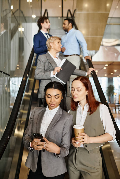 An interracial group of business people stands on an escalator. - Photo, Image