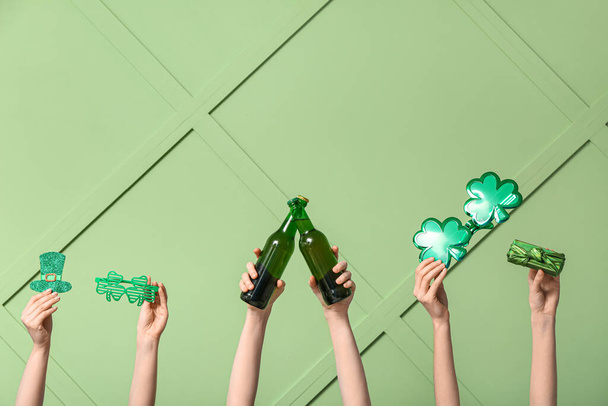 Жіночі руки тримають пиво і партійний декор для святкування Дня святого Патріка на зеленому фоні - Фото, зображення