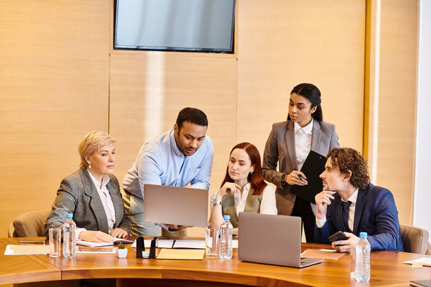 Az üzletemberek egy sokszínű csoportja együttműködik egy konferenciaasztalnál.. - Fotó, kép