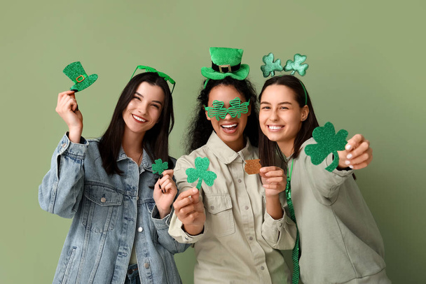 Belles jeunes femmes avec des décorations sur fond vert. Célébration de la Saint Patrick - Photo, image