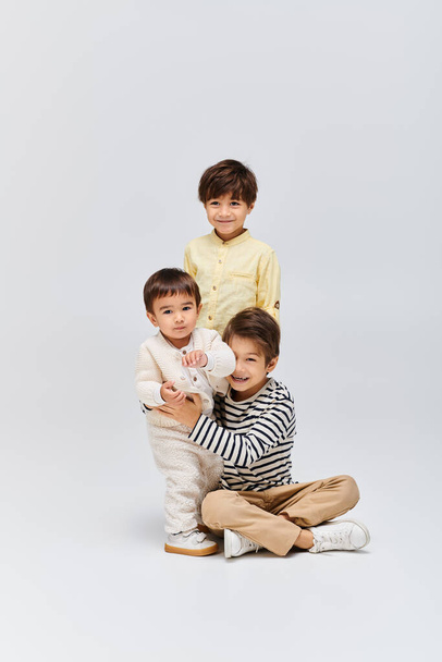 Monipuolinen ryhmä aasialaisia lapsia, jotka poseeraavat yhdessä studiossa harmaalla taustalla. - Valokuva, kuva