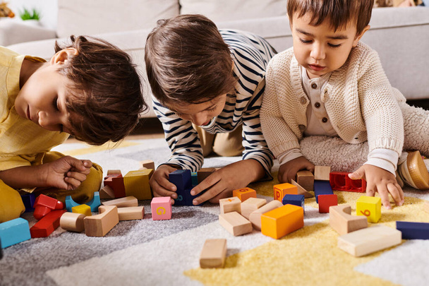 Kolme pientä lasta, todennäköisesti sisarukset, harjoittavat mielikuvituksellista leikkiä, kun he rakentavat puisia lohkoja olohuoneen lattialle.. - Valokuva, kuva