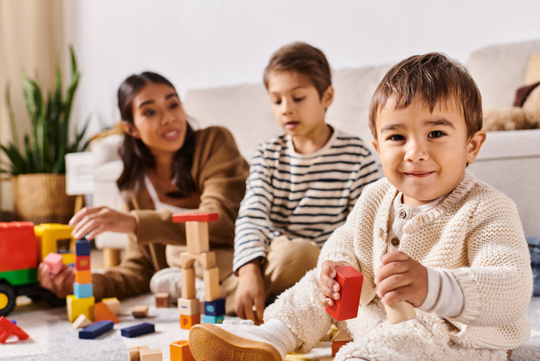 Група дітей, включаючи молоду азіатську матір та її маленьких синів, щасливо грає з дерев'яними іграшками у затишній вітальні. - Фото, зображення