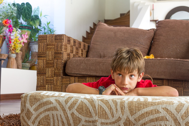indoor portret van een jonge jongen thuis tv-kijken - Foto, afbeelding