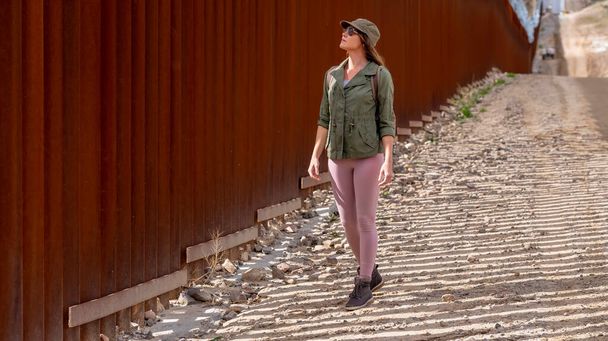 Desperate migrant navigates the Jacumba border wall, seeking illegal entry into the United States, highlighting ongoing immigration challenges - Photo, Image