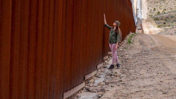 Відчайдушний мігрант орієнтується на прикордонну стіну Джакуби, шукаючи незаконний в'їзд до Сполучених Штатів, підкреслюючи поточні проблеми з імміграцією - Фото, зображення